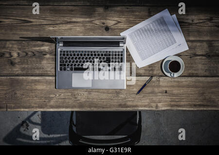 Lieu de travail avec table en bois avec coffre, de documents et de café sur elle Banque D'Images