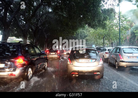 Aci Trezza, Italie, les voitures roulent sur une rue inondée par l'eau de pluie Banque D'Images
