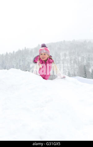 Petite fille un plaisir de jouer dans la neige Banque D'Images