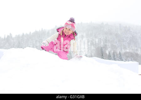 Petite fille un plaisir de jouer dans la neige Banque D'Images