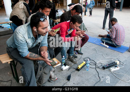 La Hongrie, Budapest, la gare Keleti. L'utilisation des réfugiés connexion Wi-Fi gratuite fournie par Greenpeace Hongrie et charger leurs téléphones portables. Banque D'Images