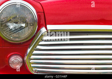 Détail de la face d'un rouge lumineux 1960 Mini car. Banque D'Images