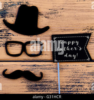 Une pancarte en forme de drapeau noir avec le texte happy fathers day et une moustache, une paire de lunettes et un chapeau qui forment le visage de Banque D'Images