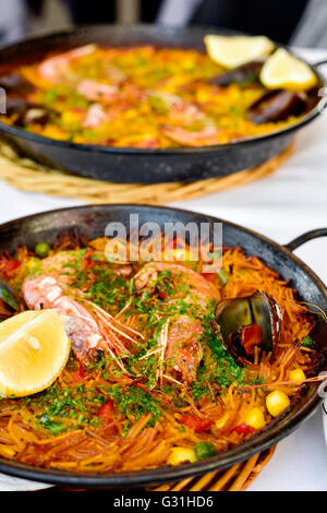 Libre d'une fideua typique espagnol, une casserole de nouilles aux fruits de mer, paella dans une casserole sur un ensemble table et une paella dans la zone Banque D'Images