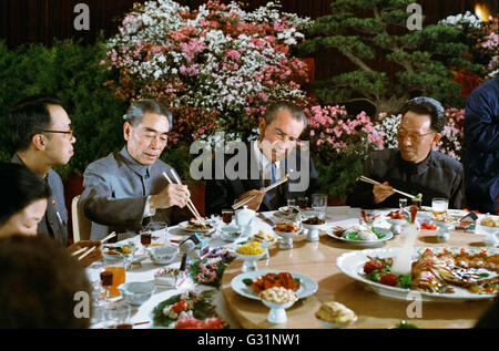 Le président américain Richard Nixon tente à l'aide de baguettes lors d'un banquet donné en son honneur par le chef communiste Premier Ministre Zhou Enlai, à gauche, et le chef du Parti Communiste Chang Chung-chiao, droite, dans le Grand Hall du Peuple, le 26 février 1972 à Beijing, Chine. Banque D'Images