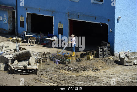 La Bavière, Allemagne. 06 Juin, 2016. Les flexibles hydrauliques vers le bas une femme tachée de boue dans des caisses de boissons Simbach am Inn, Allemagne, 06 juin 2016. Sept personnes sont mortes dans la ville à la suite des inondations qui ont également causé des dommages considérables. Dpa : Crédit photo alliance/Alamy Live News Banque D'Images