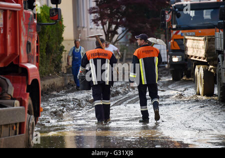 La Bavière, Allemagne. 06 Juin, 2016. Deux pompiers à pied le long d'une rue couverte de boue à Simbach am Inn, Allemagne, 06 juin 2016. Sept personnes sont mortes dans la ville à la suite des inondations qui ont également causé des dommages considérables. Dpa : Crédit photo alliance/Alamy Live News Banque D'Images