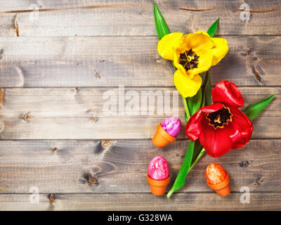 Arrière-plan de Pâques. Les oeufs de Pâques et tulip fleurs de printemps sur des planches. Maison de concept. Copier l'espace. Haut de la vue, télévision lay Banque D'Images