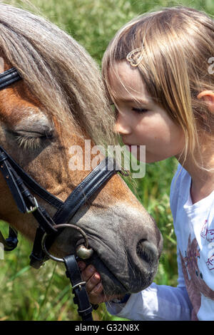 Enfant de 6 ans, petite fille avec poney, caressant poney enfant Banque D'Images