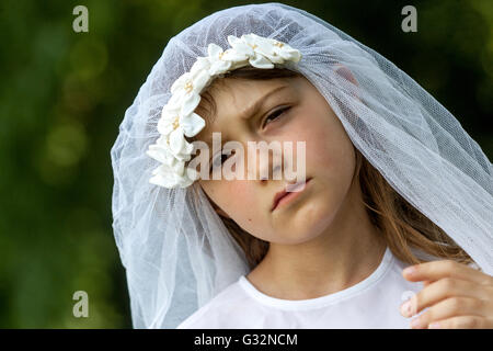 Age of innocence 6-7 ans Old Girl White Bridal Veil bride Game Child face Sad expression Sad Girl Outside Banque D'Images