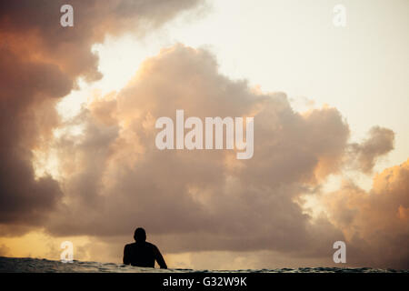 Silhouette de surfeur qui attend pour attraper une vague de pluie, Hawaii, États-Unis Banque D'Images