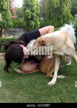 Femme jouant avec deux chiens dans le jardin Banque D'Images