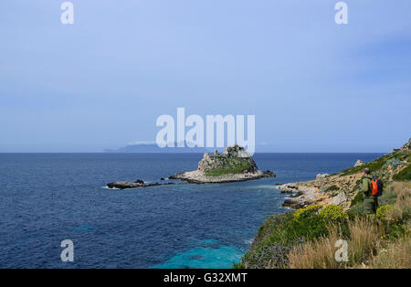 Talie, Sicile, îles Egadi, l'île de Levanzo, randonneur sur un sentier côtier avec vue sur mer avec Borgo Italia 77 île en arrière-plan Banque D'Images