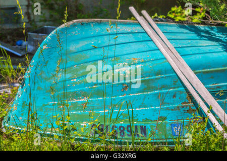 Détail de droit d'un vieux bateau en fibre de verre dans un jardin envahi par la pose Banque D'Images