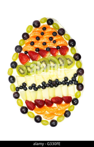 Gâteau aux fruits en forme d'oeuf recouvert de divers fruits isolé sur fond blanc Banque D'Images