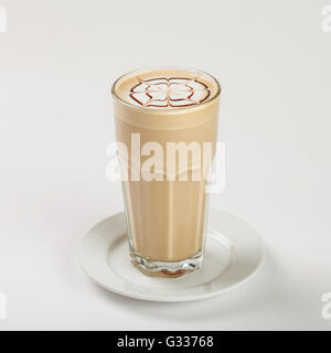 Délicieux latte dans un grand verre sur la plaque sur fond blanc. Close up Vue de côté. Banque D'Images