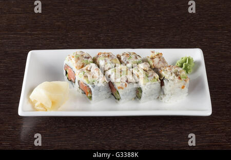 Rouleaux de Sushi sur une plaque avec du thon et du gingembre sur table en bois brun foncé. Vue de côté. Banque D'Images
