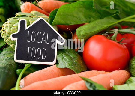 Libre d'une maison en forme de tableau sur les aliments locaux texte placé sur un tas de certains légumes crus différents, comme cucumbe Banque D'Images