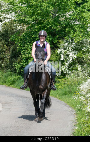 Horse Rider sur un chemin de campagne dans la campagne anglaise. Un jour d'été ensoleillé. Banque D'Images