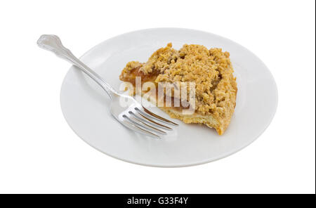 Vue latérale d'une tranche de tarte aux pommes hollandaise sur une assiette avec une fourchette isolé sur un fond blanc. Banque D'Images