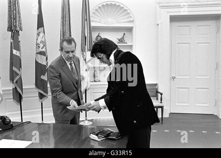 Elvis Presley présente une photographie autographiée de président américain Richard M. Nixon dans le bureau ovale à la Maison Blanche le 21 décembre 1970 à Washington, DC. La réunion a été ouverte par Presley, Nixon qui a écrit une lettre de six pages en vue d'une visite avec le président et en suggérant qu'il soit fait un 'agent fédéral-at-large' dans le bureau des narcotiques et des drogues dangereuses. Banque D'Images