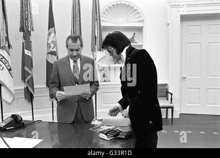 Elvis Presley présente une photographie autographiée de président américain Richard M. Nixon dans le bureau ovale à la Maison Blanche le 21 décembre 1970 à Washington, DC. La réunion a été ouverte par Presley, Nixon qui a écrit une lettre de six pages en vue d'une visite avec le président et en suggérant qu'il soit fait un 'agent fédéral-at-large' dans le bureau des narcotiques et des drogues dangereuses. Banque D'Images