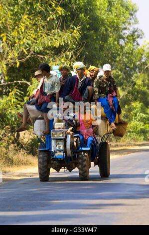 Le Myanmar. Bagan Mandalay Personne à bord d'un tracteur pour retour de vêtements typiques d'un marché à un retour dans la remorque Banque D'Images