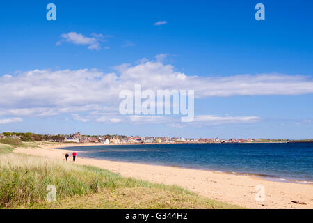 Deux personnes marchant sur une plage de sable tranquille dans village sur la côte du Firth of Forth. Elie et de Earlsferry, East Neuk de Fife Fife, Scotland, UK Banque D'Images