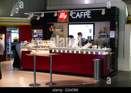 Marque Illy Caffe / cafe café qui sert / est servant des boissons et des collations aux passagers à l'aéroport de Milan, Italie. Banque D'Images