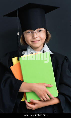 Lycéenne en academic hat avec books Banque D'Images