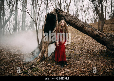 Jeune sorcière dans la forêt d'automne Banque D'Images