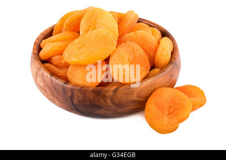 Abricots secs dans une tasse en bois sur fond blanc. Libre. Banque D'Images