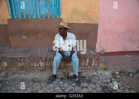 Cuba vieille homme portant un chapeau de paille se trouve dans les petites rues de Trinidad Cuba regarder le monde passer par début de soirée Banque D'Images