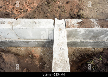 Blocs de construction en béton construction gris utilisé pour les fondations d'une auto-construction maison. Pour les tranchées et creusé hors terre entourent Banque D'Images