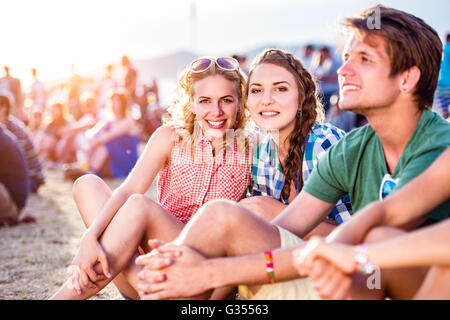 Les adolescents au festival de musique d'été, assis sur le sol Banque D'Images