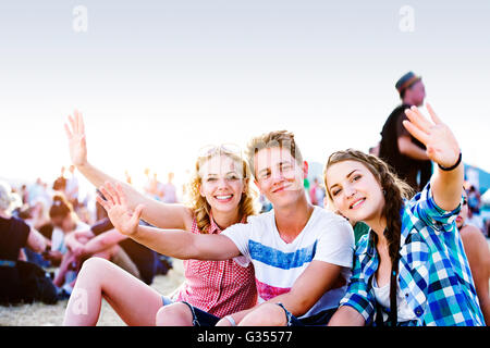 Les adolescents au festival de musique d'été, assis sur le sol Banque D'Images