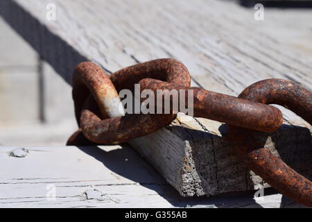 Close up de chaîne rouillée liens contre les planches de bois Banque D'Images