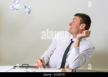 Papiers froissés en battant young businessman face Banque D'Images