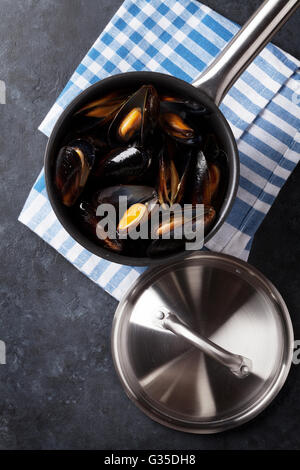 Moules dans marmite en cuivre sur table en pierre. Vue d'en haut Banque D'Images