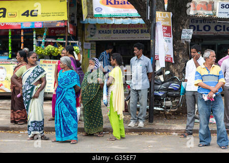 Un groupe d'Indiens en attente d'un bus local de Mylapore, Chennai, Tamil Nadu, Inde, Asie Banque D'Images