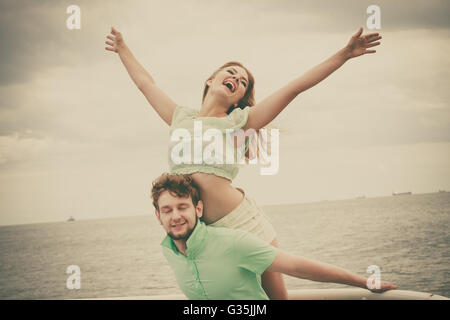 Le bonheur d'été concept. La femme et l'homme jeune couple amoureux jouer partager temps libre s'amuser en plein air, sur fond de ciel mer pier Banque D'Images