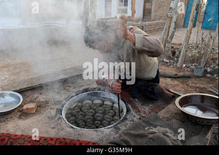 Chine Xinjiang province, ville Kashgar où uyghur personnes vivent, une boulangerie dans la rue au village, la cuisson du pain bagel au four en argile Banque D'Images