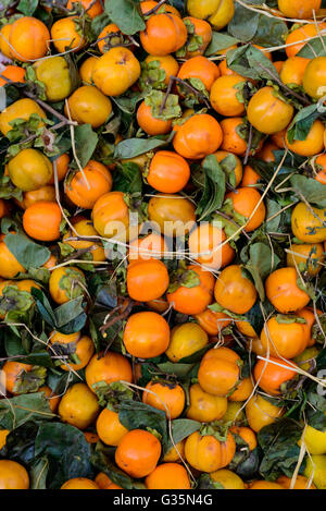 Fruits Kaki en vente sur un étal du marché Banque D'Images