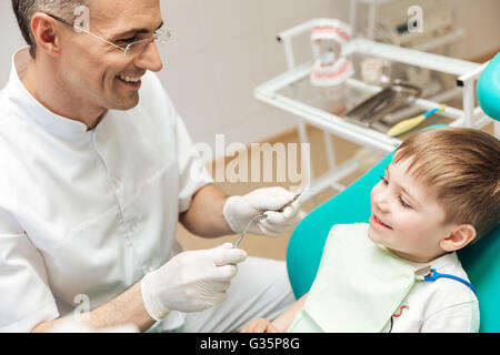 En faisant sourire dentiste lunettes traitement dentaire pour petit garçon Banque D'Images