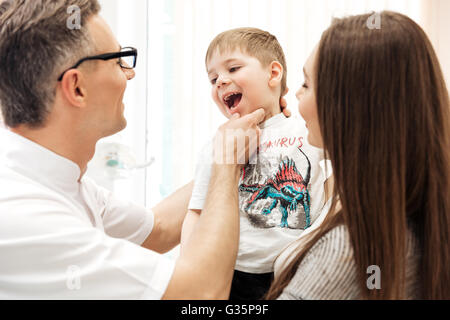 L'examen des dents dentiste petit garçon avec sa mère à l'observation clinique dentaire Banque D'Images