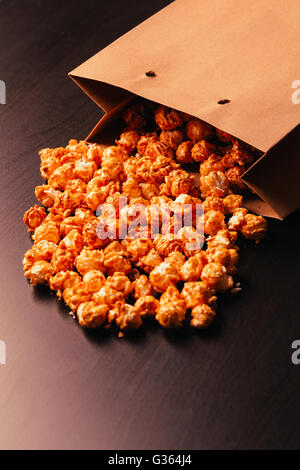 Fun eating popcorn sac de papier sur un fond sombre. Banque D'Images