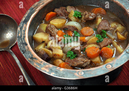 Photo de de Guinness Irish Stew ou ragoût dans une vieille marmite en cuivre bien usé. Banque D'Images