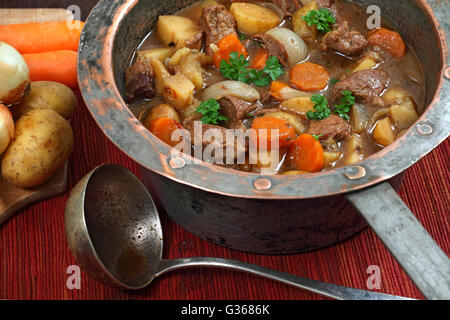 Photo de de Guinness Irish Stew ou ragoût dans une vieille marmite en cuivre bien usé. Banque D'Images