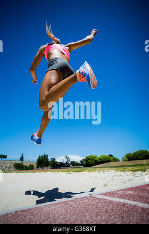 Athlète féminin effectuant un long saut Banque D'Images