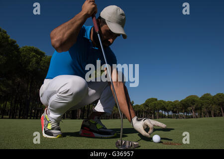 Close up of man's hand putting balle de golf dans le trou en cours Banque D'Images